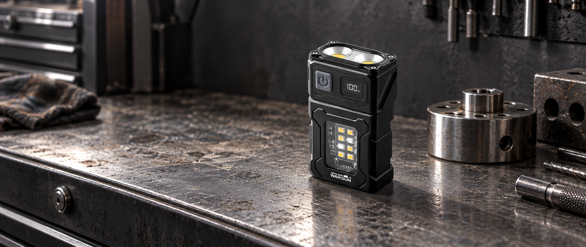 Black WARSUN DC08 swivel-head flashlight on a steel workbench beside machined metal parts